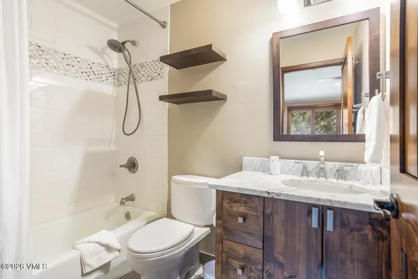 a bathroom with a granite countertop sink toilet and shower