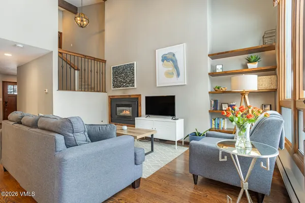 a living room with furniture wooden floor and a flat screen tv