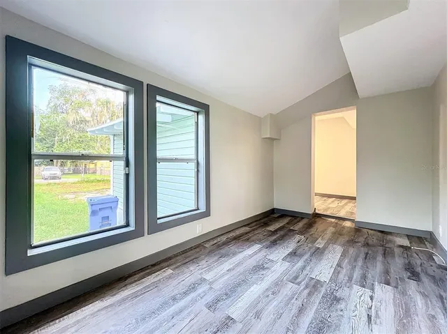 a large kitchen with granite countertop a stove top oven a sink dishwasher a dining table and chairs with wooden floor