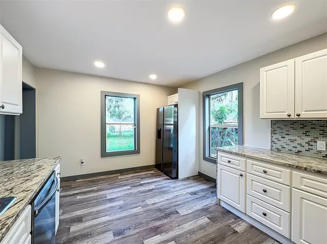 a view of a hallway with wooden floor and closet