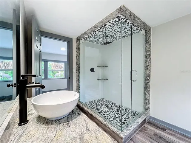 a view of a hallway with wooden floor and windows