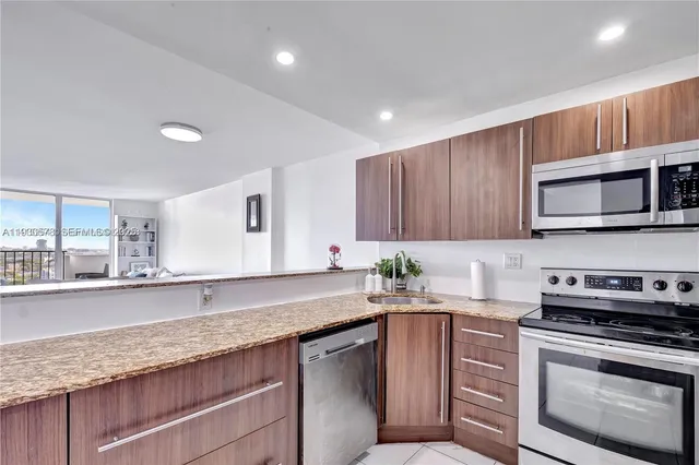 a kitchen with stainless steel appliances granite countertop a sink stove and microwave