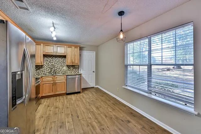 a kitchen with stainless steel appliances a refrigerator and a stove