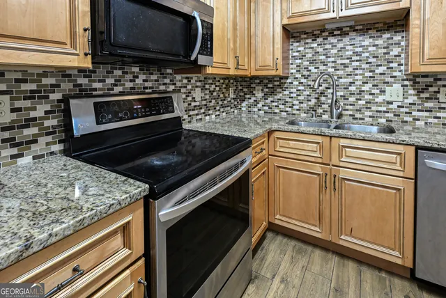 a kitchen with granite countertop cabinets stove top oven and microwave