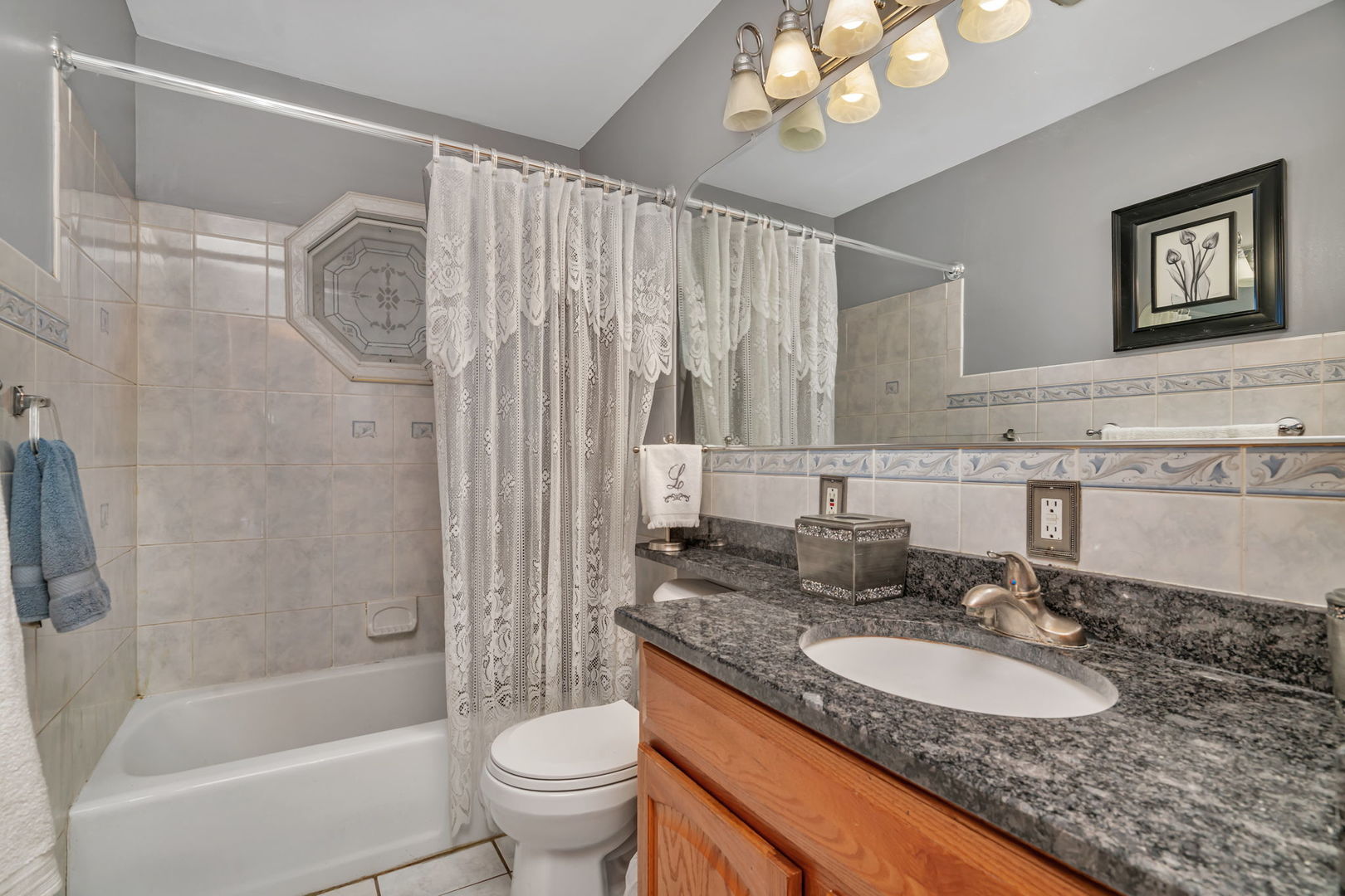 334 Hemlock Avenue Romeoville, IL 60446 - Photo 11 of 24 a bathroom with a granite countertop sink a toilet a mirror a vanity a bathtub and shower