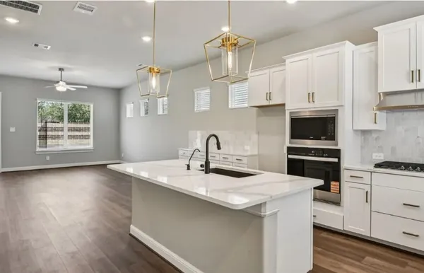 a kitchen with a sink a stove and cabinets