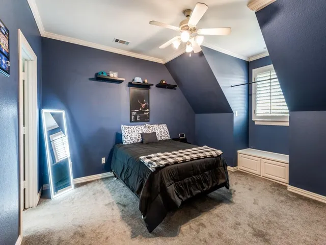 a bedroom with a bed chandelier and a window