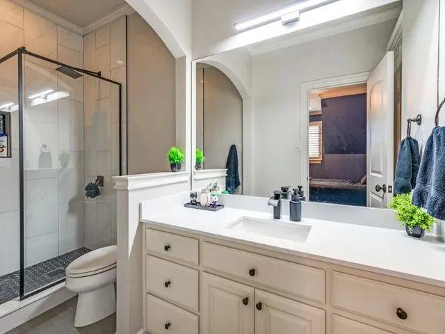 a bathroom with a sink a toilet and shower