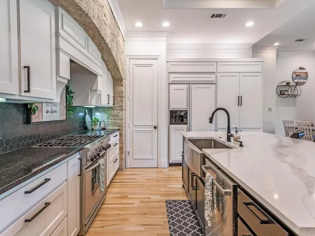 a kitchen with kitchen island granite countertop a sink and cabinets