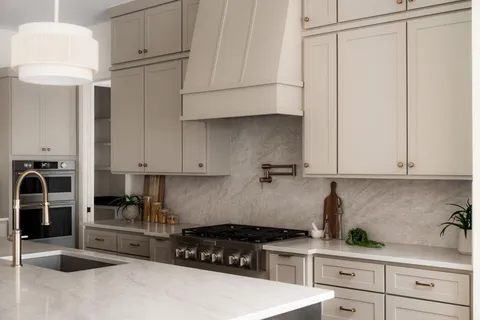 a kitchen with stainless steel appliances granite countertop a stove a sink and white cabinets