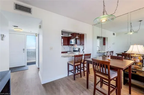 a view of a a dining room with furniture window and wooden floor