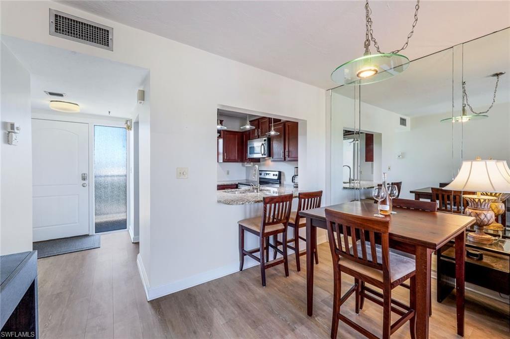 803 River Point Drive, Unit 201B Naples, FL 34102 - Photo 12 of 21 a view of a a dining room with furniture window and wooden floor