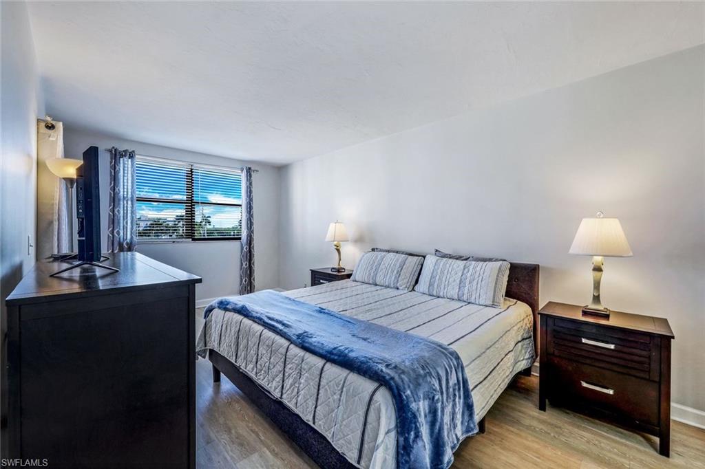 803 River Point Drive, Unit 201B Naples, FL 34102 - Photo 13 of 21 a bedroom with a bed and a table