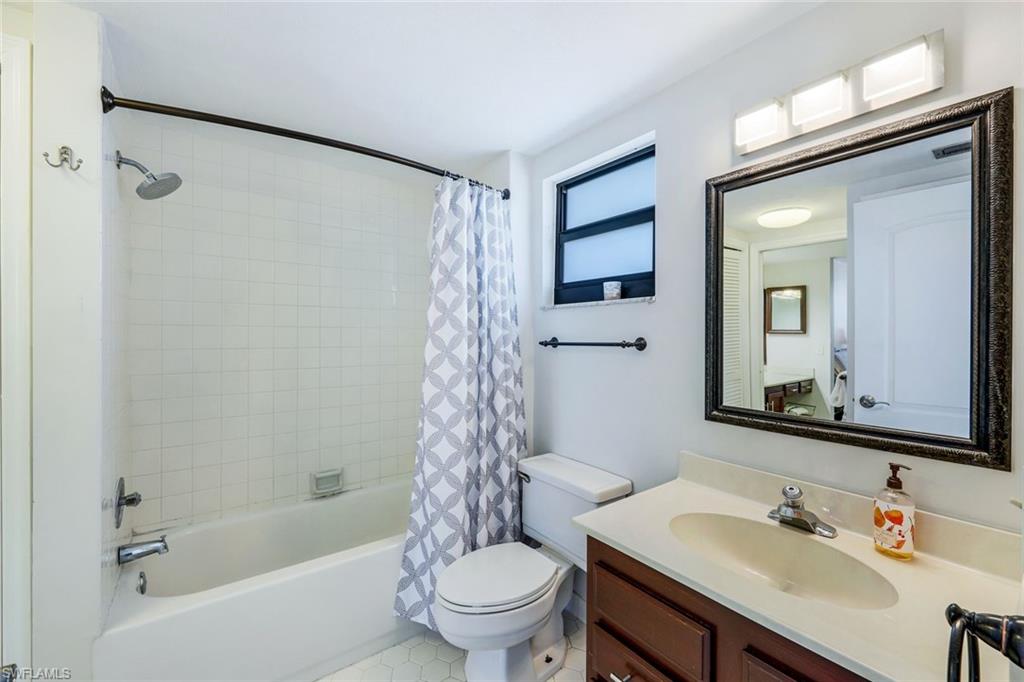 803 River Point Drive, Unit 201B Naples, FL 34102 - Photo 16 of 21 a bathroom with a sink a toilet and a mirror