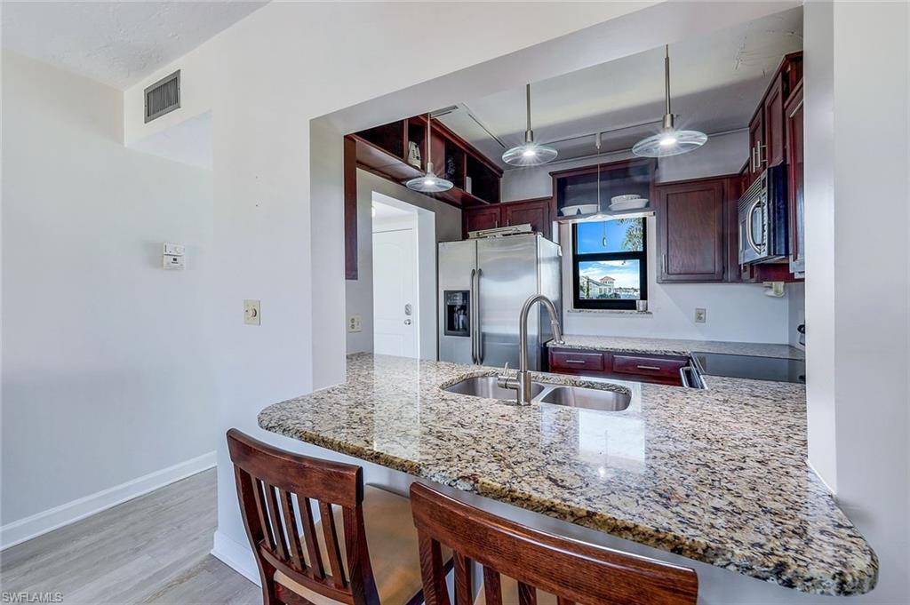 803 River Point Drive, Unit 201B Naples, FL 34102 - Photo 6 of 21 a bathroom with a granite countertop sink and a mirror