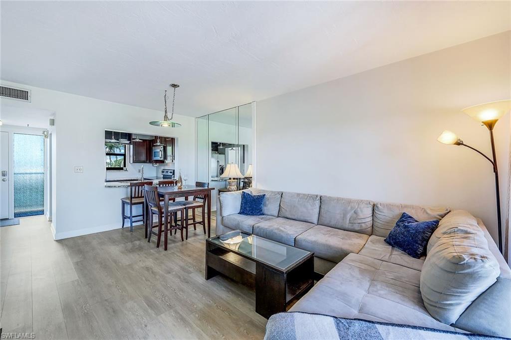 803 River Point Drive, Unit 201B Naples, FL 34102 - Photo 8 of 21 a living room with furniture kitchen view and a wooden floor