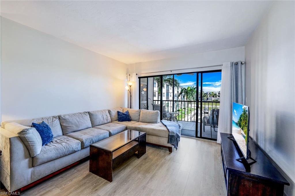 803 River Point Drive, Unit 201B Naples, FL 34102 - Photo 9 of 21 a living room with furniture and a flat screen tv