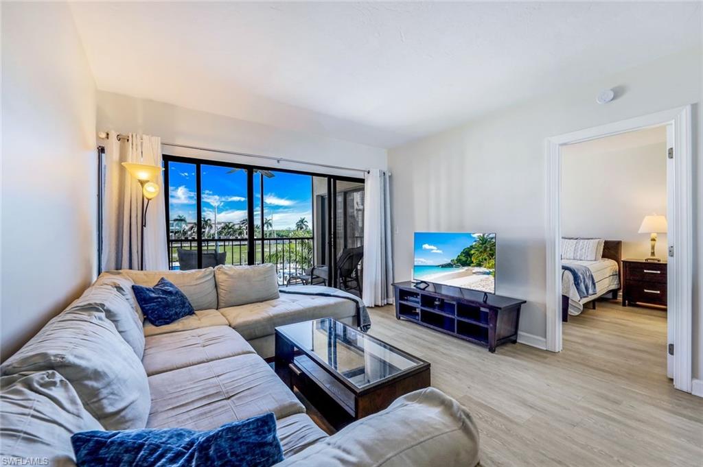 803 River Point Drive, Unit 201B Naples, FL 34102 - Photo 10 of 21 a living room with furniture and a flat screen tv