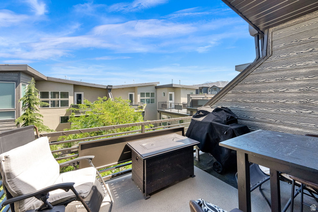 7713 Navarro View Court Midvale, UT 84047 - Photo 24 of 41 Expansive outdoor deck featuring a gray concrete surface, dark gray wood-look accent wall, and metal railings