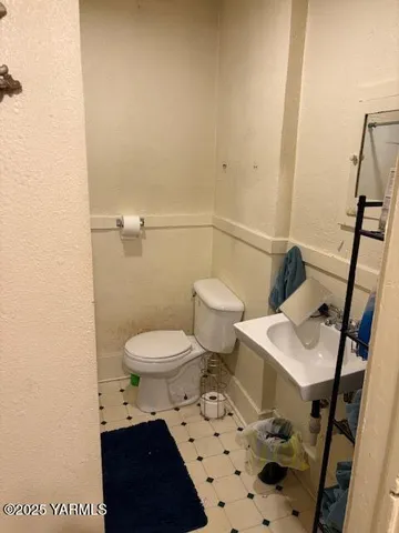a bathroom with a toilet a sink and a mirror