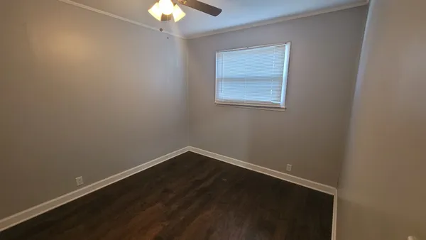 a view of a small space with wooden floor and a window