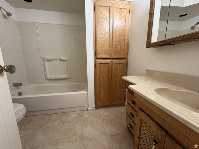 486 West 120 North Orem, UT 84057 - Photo 17 of 30 Full bathroom featuring a single vanity with integrated sink, wood-finish cabinetry, built-in shelving, a shower/tub combination, and tiled flooring