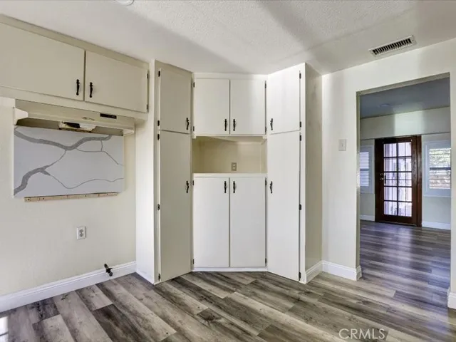 a view of a room with wooden floor and cabinet