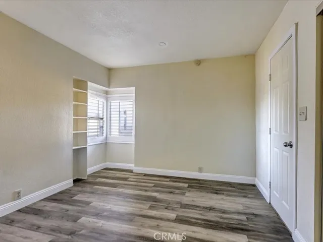 a view of a room with a closet and wooden floor