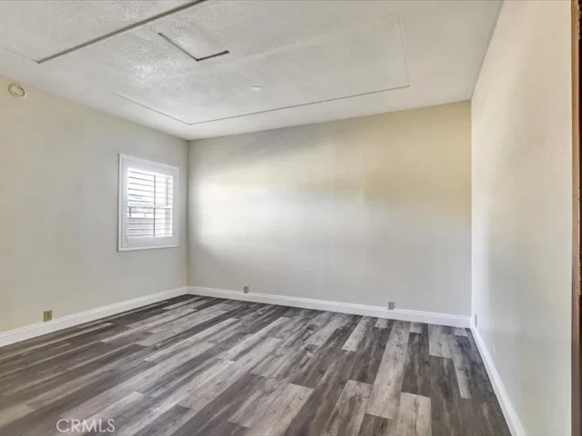 a view of empty room with wooden floor and closet