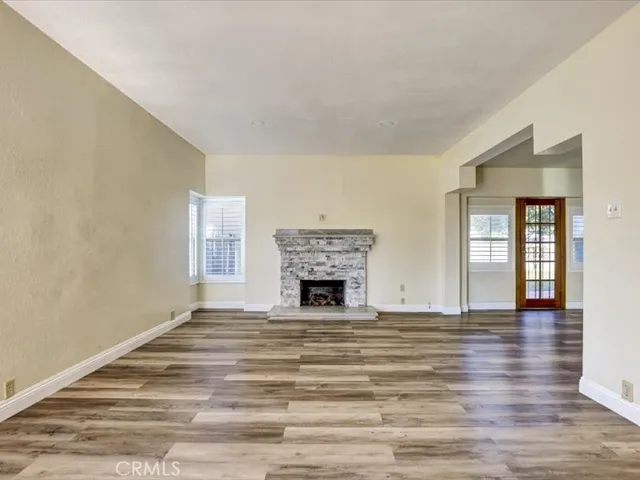 a view of a livingroom with a fireplace window and wooden floor