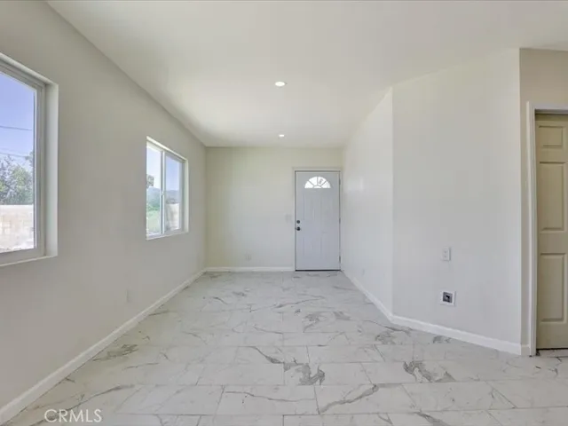 a kitchen with white cabinets and window
