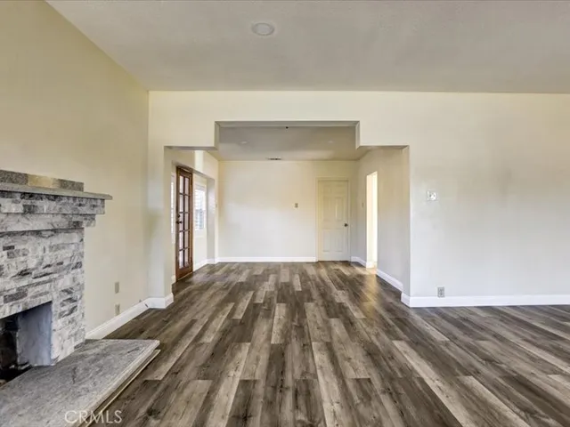 a view of a livingroom with wooden floor and a fireplace