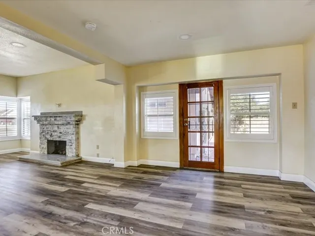 a view of an empty room with window and fireplace