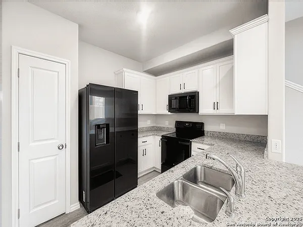 a kitchen with stainless steel appliances granite countertop a refrigerator stove and sink