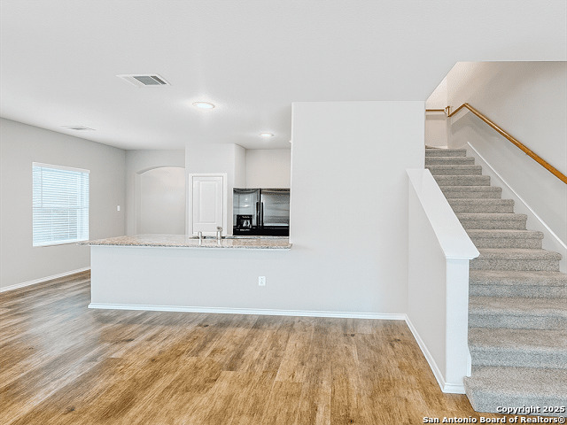 3831 Key W Way Converse, TX 78109 - Photo 4 of 18 a view of kitchen and empty room with wooden floor