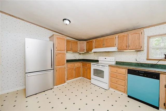 a kitchen with granite countertop a refrigerator and a sink