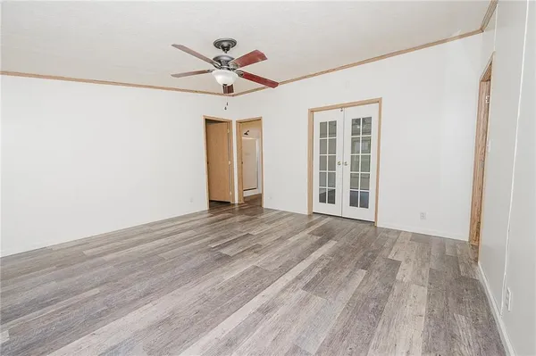 a view of an empty room with a window and wooden floor