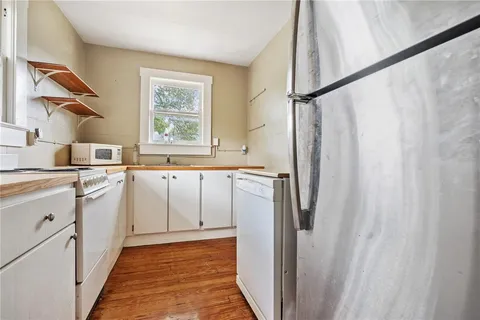 a kitchen with white cabinets and white appliances
