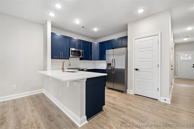a kitchen with a refrigerator a sink and cabinets