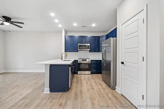 a kitchen with wooden floors and wooden cabinets