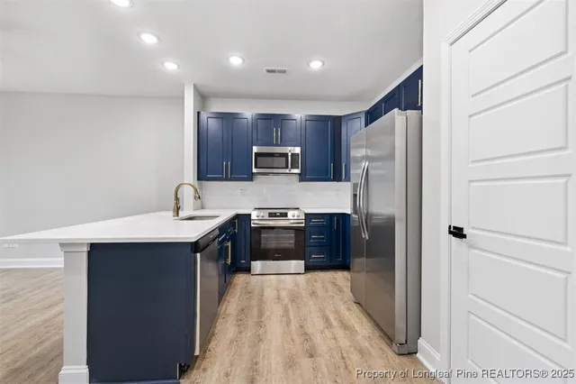 a large kitchen with a refrigerator and a sink