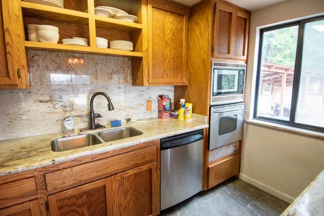 a living room with a couch and a stove with wooden floor