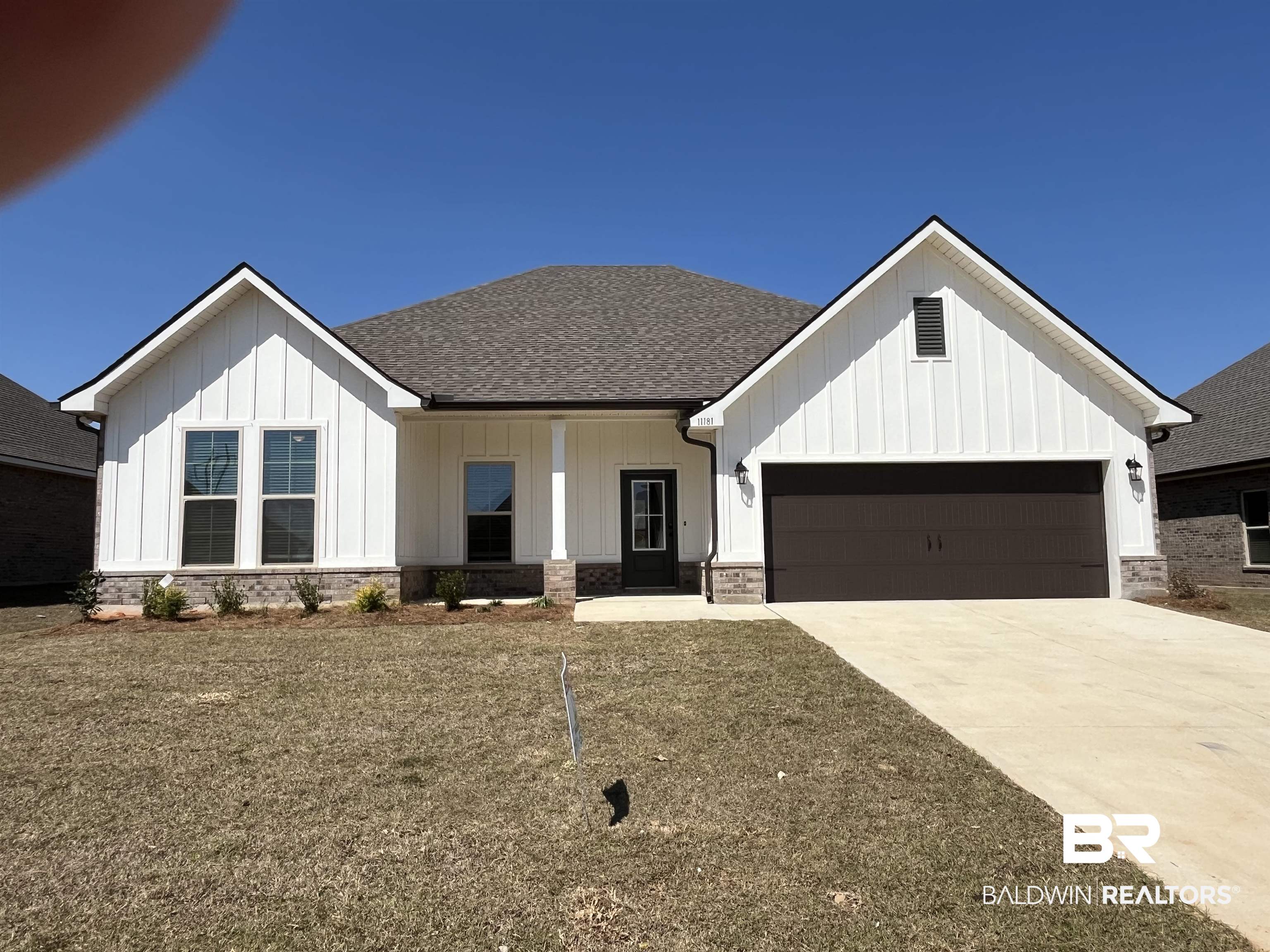 11181 Bonaventure Avenue Daphne, AL 36526 - Photo 1 of 3 Modern inspired farmhouse featuring board and batten siding, a shingled roof, covered porch, and concrete driveway