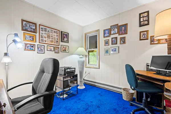 a view of a workspace with furniture and a window