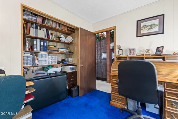 a view of a workspace with furniture and wooden floor
