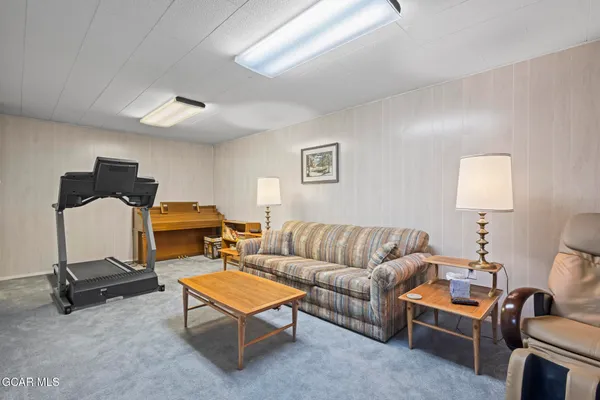 a living room with furniture a flat screen tv and a lamp