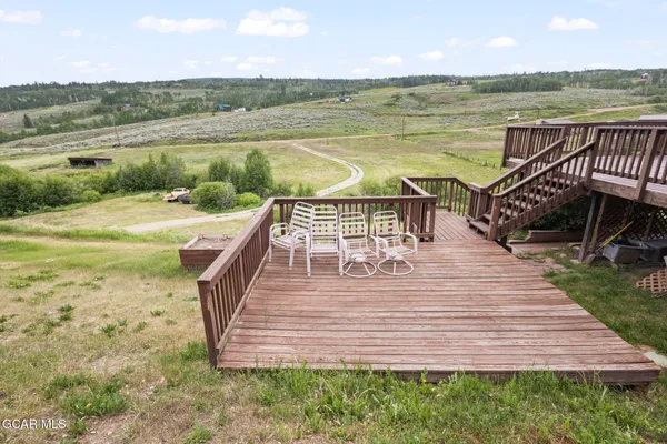 a view of a lake with a wooden deck and a yard