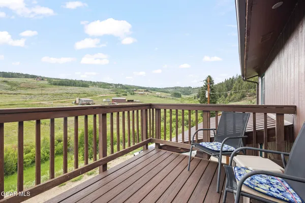 a view of balcony with wooden floor & fence