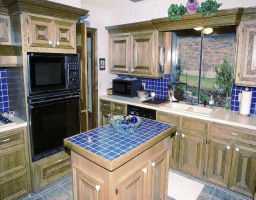 a kitchen view of a kitchen island wooden cabinets and a refrigerator