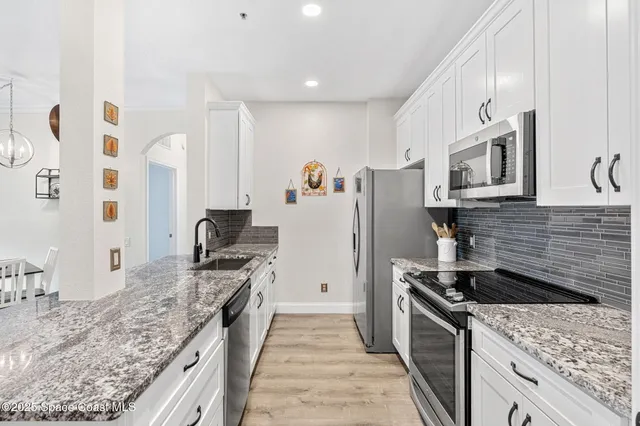 a kitchen with stainless steel appliances granite countertop a stove and a refrigerator